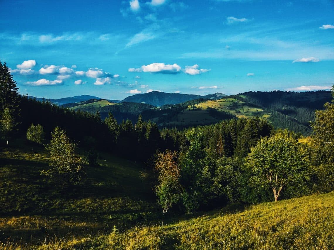 Osvetljeni planinski vrhovi iznad talasastih grebena